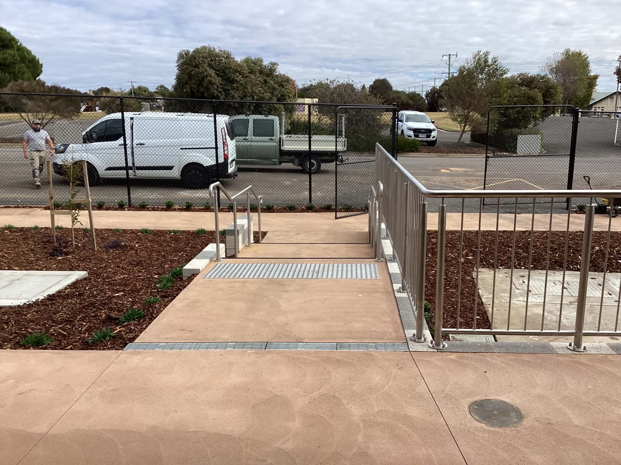 Long stainless steel railing installed beside a commercial access path