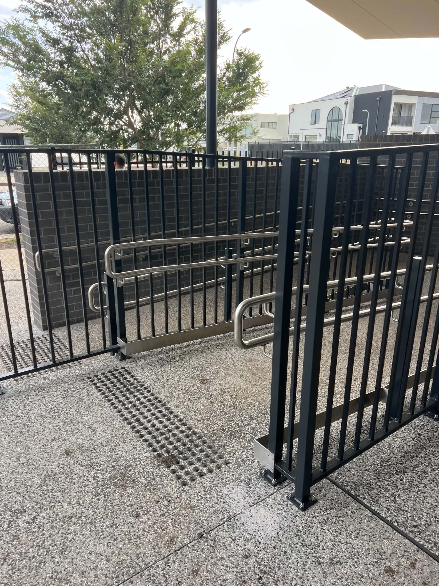 Black balustrades and stainless assist rails on an outdoor access ramp