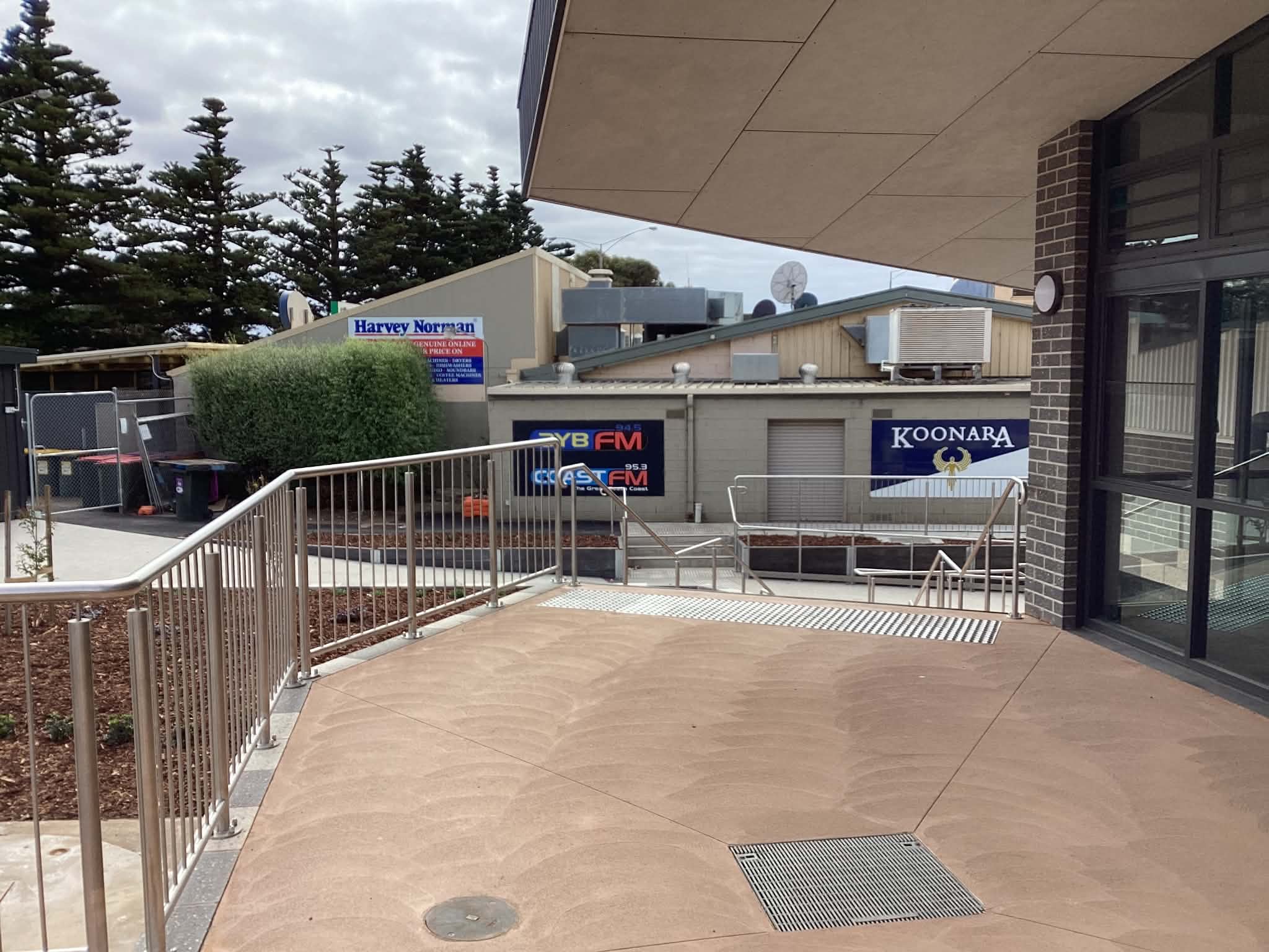Long stainless handrail and balustrade installation along a commercial access ramp