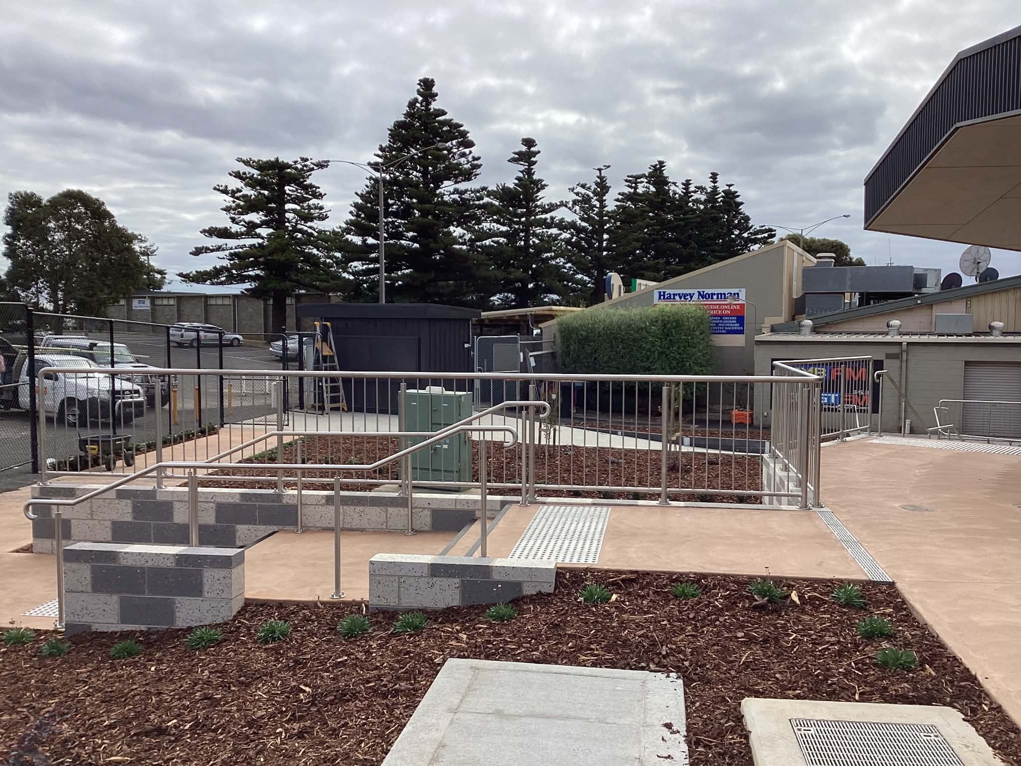 Commercial stainless steel handrails installed across an accessible public ramp